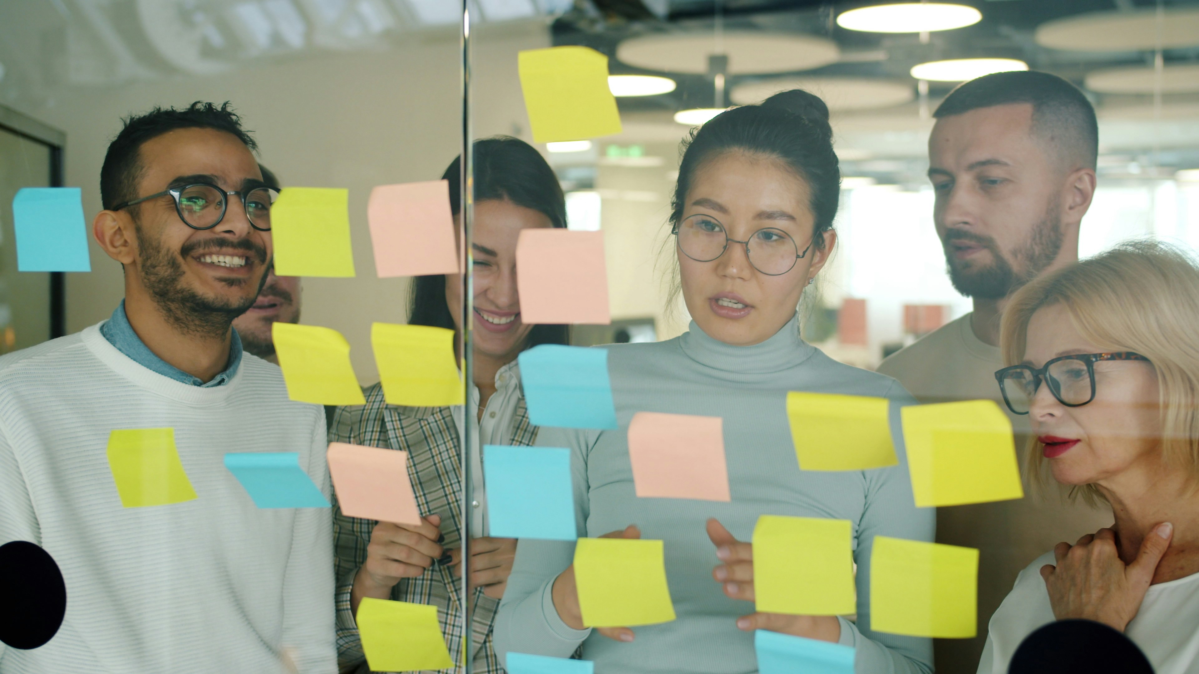 A team collaborating with notes on a glass wall